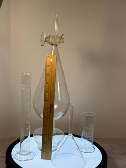 (5) Assorted collection of laboratory glassware featuring a pear-shaped glass separatory funnel (center) alongside a graduated cylinder, a powder/liqu