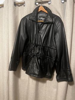Genuine black leather jacket from Wilsons Maxima. This garment has a full-zip front closure and a high collar. It features adjustable drawstring toggl