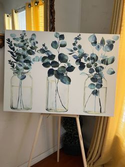 Art, framed, colors are very beautiful. They’re inside a bottle there’s green on the border of the bottles with yellow and also it’s blue grey leaves 