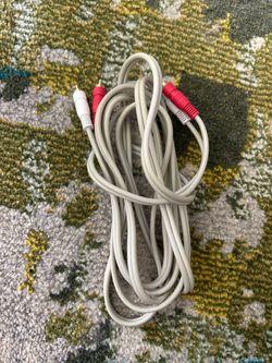 Se trata de un cable de audio estéreo RCA macho a macho de color blanco.