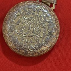 vintage Impex pendant watch with a gold-tone case and black dial.