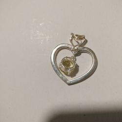 
This is a 925 sterling silver open heart pendant with a round, yellow citrine gemstone. 