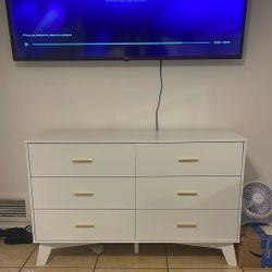White dresser with gold appliances 