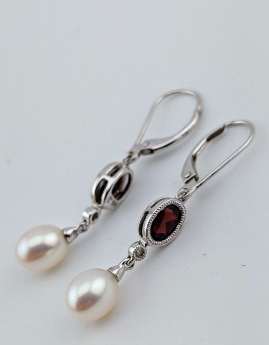 Elegant pair of 14k white gold Garnet, Diamond, and Pearl drop earrings.