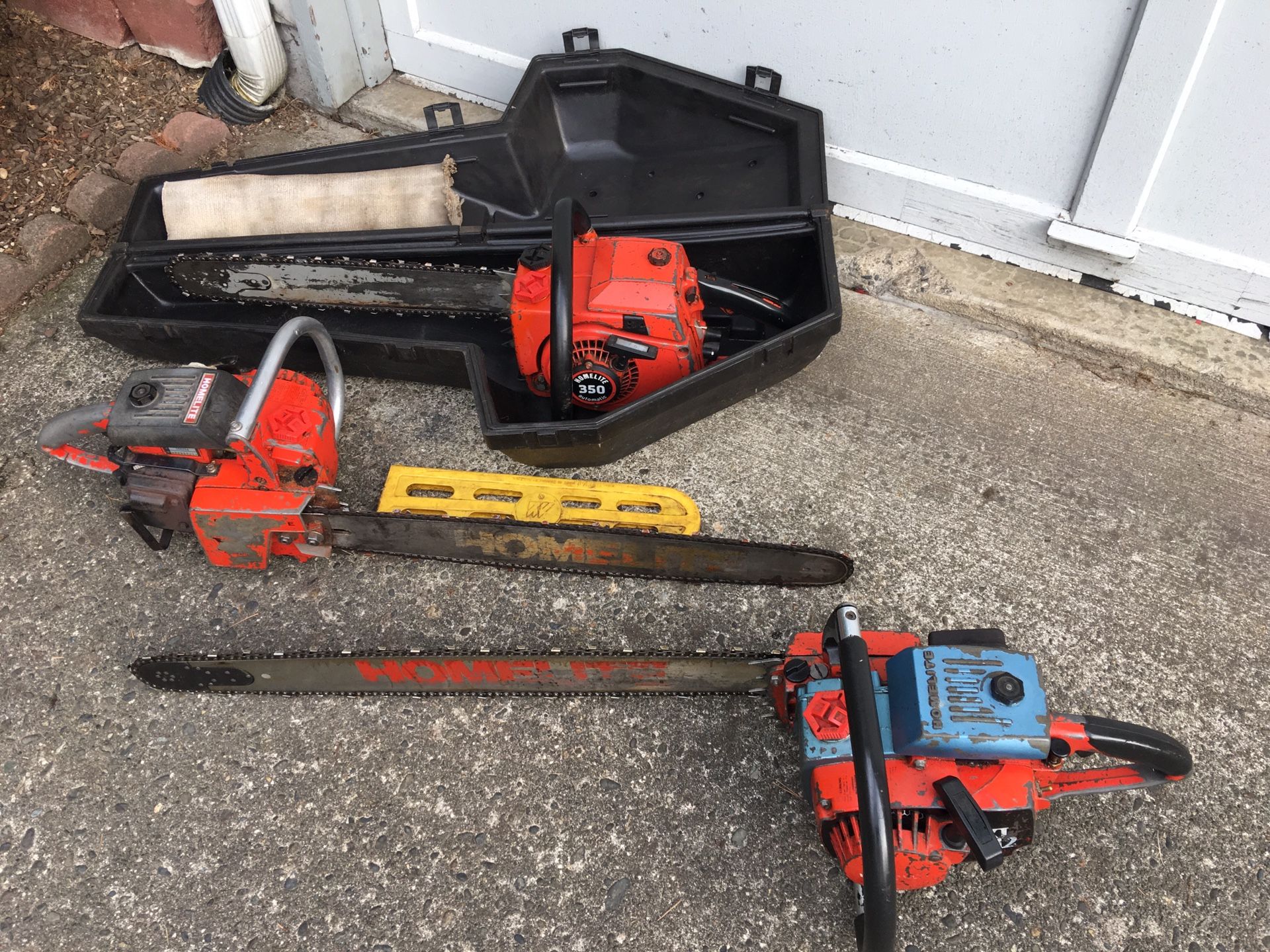 Three older homelite chainsaws with case. Run and cut good 20 inch bar 24 inch bar and 28 inch