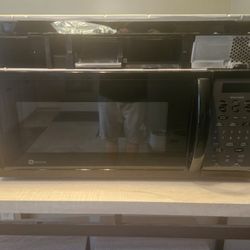 Black Microwave Hangs Above Stove