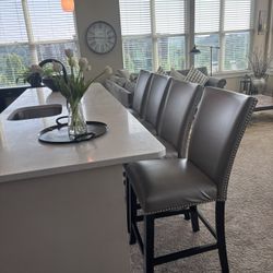 A set of four light, gray leather counter chairs