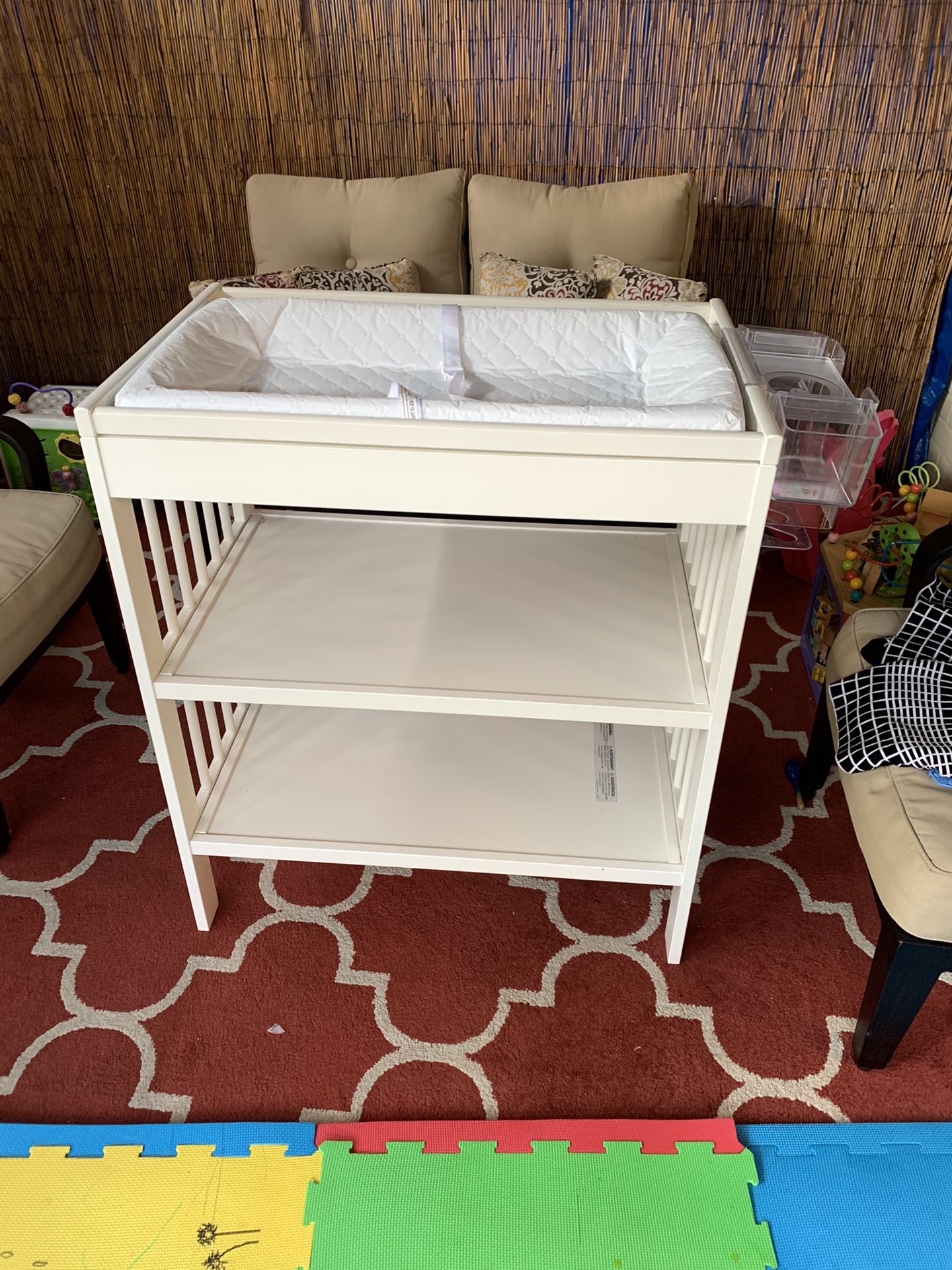 I les changing table, with changing pad and diaper organizer.