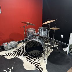 silver drum kit, seat, and animal rug