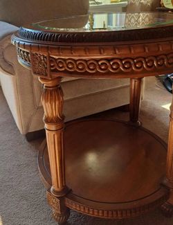 Table round wood and Beveled glass-top end or side table a dark wood finish, fluted or carved legs, an egg-and-dart or carved apron, and a lower circ