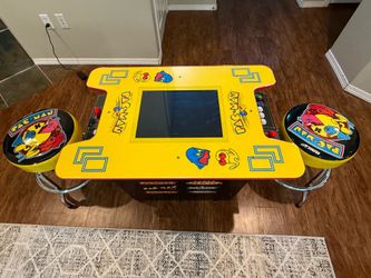 ARCADE 1UP PACMAN table top electronic game with two chairs and paperwork