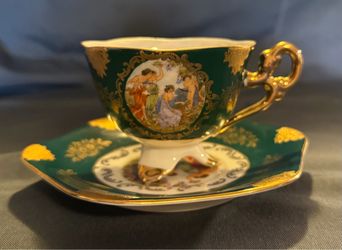 Vintage porcelain footed teacup and saucer set with gold gilt and cherubs