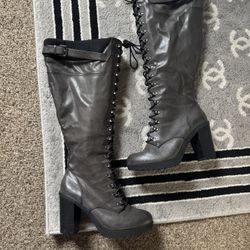 Black leather knee-high boots with lace-up closure and side zipper