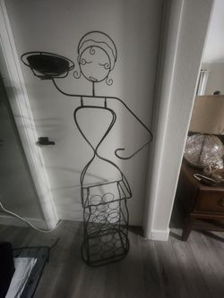 Iron wine rack sculpture in the shape of a woman.