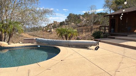 Solar pool cover with roller