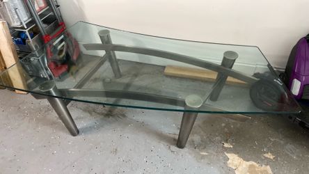 Glass Coffee Table – $100  Modern glass coffee table in excellent condition. Features a thick tempered glass top with a stylish curved design and stur
