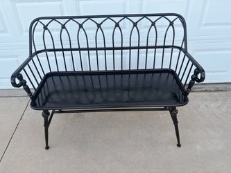 Black metal bench with decorative back