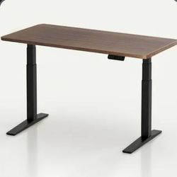 Sit to stand desk includes a file drawer with red cushion