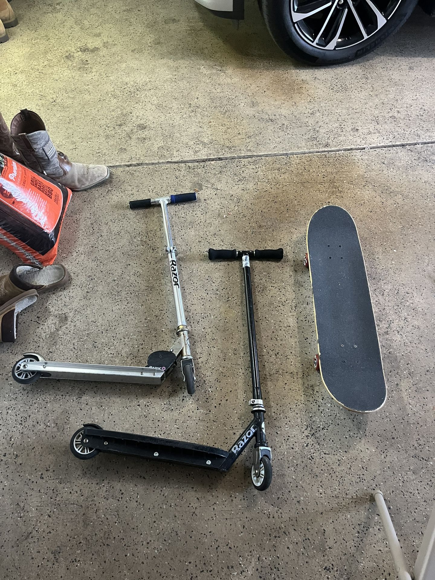 Two Razor Scooters and One Mongoose Skateboard