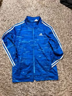 Blue adidas tracksuits with white strips and wavy pattern