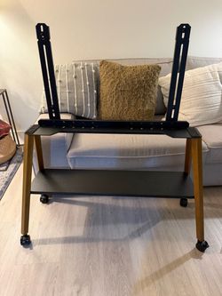 Rolling Easel TV Stand for 49-75" TVs, 88 lbs, Black Wood-and-metal mobile TV cart, locking 360° wheels