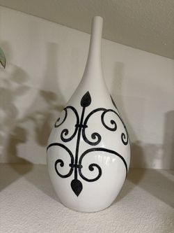 Elegant ceramic vase has a white finish with a black scrollwork pattern.