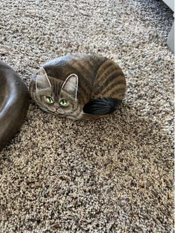 One painted rock cat and concrete cat.