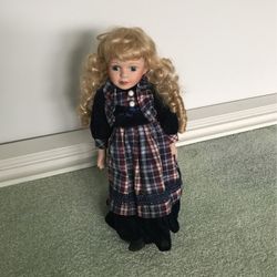 Girl doll with Curly blonde hair, blue eyes and black and plaid dress