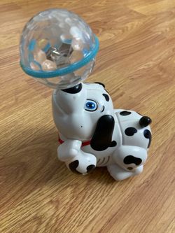 Cute Dalmatian toy holding a light-up ball.
