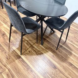 Grey round dining table with chairs