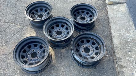 Five matching D-hole style 15x8 inch black steel wheels for a Chevy or GMC truck