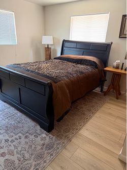 Queen size sleigh bed with boxspring and mattress.
