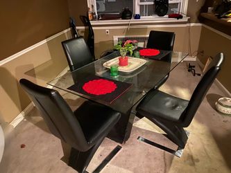 Glass Top Dining Table with 4 black leather Chairs and red slip covers