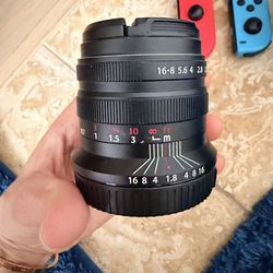 Brightin Star 55mm F1.8 (or Koah Artisans 55mm f/1.8) manual focus mirrorless camera lens.