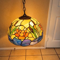 Tiffany-style stained glass pendant lamp featuring a vibrant lotus flower design.   