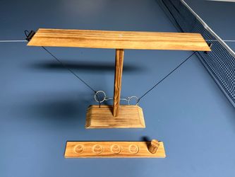 The Wood Tabletop Ring & Hook Toss Game is a classic and challenging game suitable for ages 17 and up. Made from high-quality brown wooden materials, 
