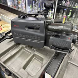 Vintage Panasonic VHS camcorder with case and accessories. Includes original carrying case, charger, and other extras.