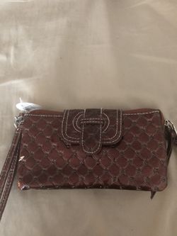 Brown clutch wallet with wrist strap and long strap included. Brand new still has tags and paper wrapped around it. $7 or best offer.