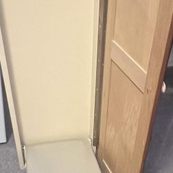Garment care center with ironing board and storage space.