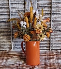 Ht-16in width-14 in HANDMADE artificial Fall arrangement in a rust color pitcher