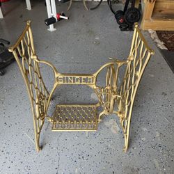 Vintage Singer Cast Iron Sewing Machine Base  a beautifully detailed vintage Singer cast iron sewing machine base in gold. 	•	Dimensions: 23” wide x 1
