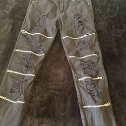 Black ripped jeans with zippers.
