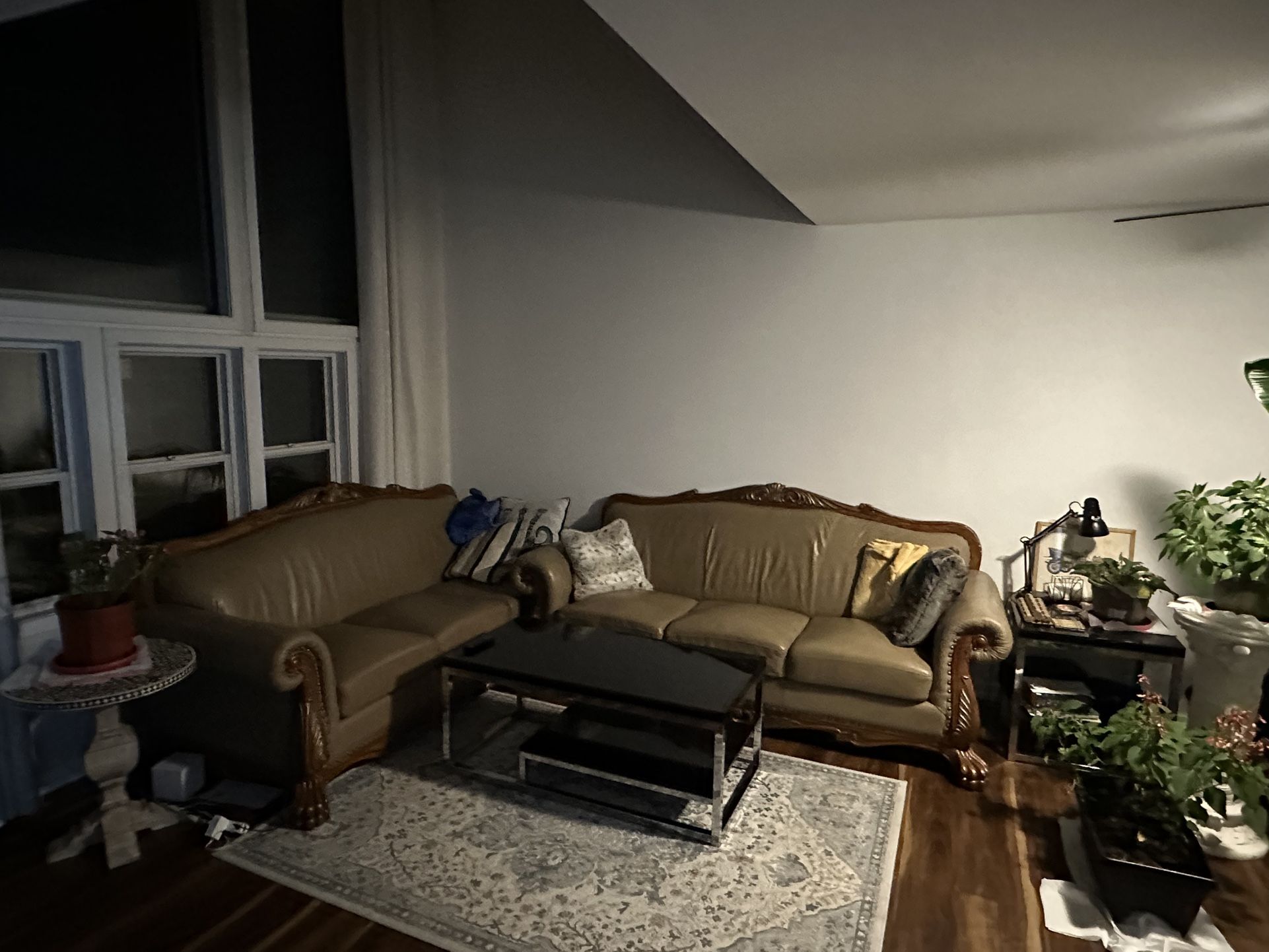 2 Beautiful, beige leather Couches with carved wooden accents.