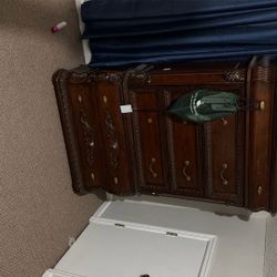 A Hard Wooden Queen Size Bed With The Mattress And 2 Dressers.