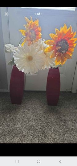 Pair of red vases with artificial sunflowers and daisies
