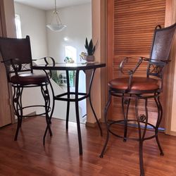 square table and two tall metal chairs with beautiful accents.