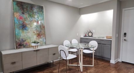 West Elm Round Glass Dining Table with a white powder-coated steel base.