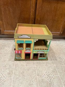 Serious buyers only please. Detailed plastic playset with a two-story building design featuring a toy store and department store. This yellow and gree