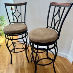 Classic black iron swivel bar stools with wood accent and beige microfiber cushions