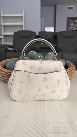Disney × Coach Frame Bag 23 with Dalmatian Floral Print  Color: Chalk (cream/ivory) Style #: 68932 Collection: Disney × Coach — 101 Dalmatians